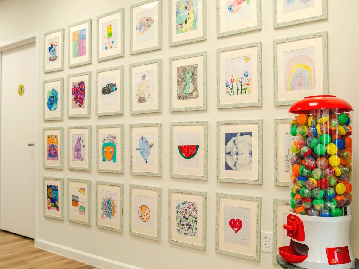 The Prize Machines — token prize machines beside a wall of framed patient artwork