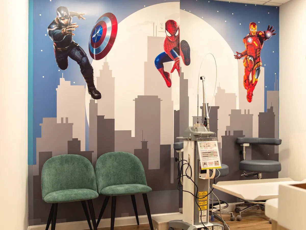 Superhero City — themed treatment room with a city-skyline mural